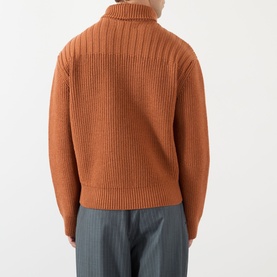 Model wearing Dries Van Noten Marino Rib-Knit Cardigan in Ocra, showing ribbed back detail, funnel neck and dropped shoulders, styled with grey
