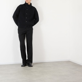 Model wearing Dries Van Noten black wool cardigan with button front, styled with matching black trousers and leather shoes.
