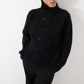 Model wearing Dries Van Noten black wool cardigan with asymmetric button placket and high neck, styled with matching black trousers.