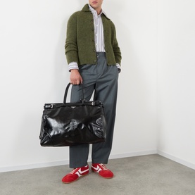 Model wearing Dries Van Noten Mora Brushed Knitted Cardigan in Forest Green with grey trousers, styled with a striped shirt and red trainers.