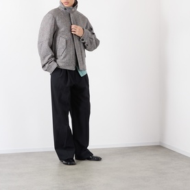Model wearing Dries Van Noten black wool casual jacket with black wide-leg trousers and black loafers.
