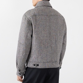 Model wearing Dries Van Noten black wool casual jacket, rear view showing button fastenings and structured silhouette, styled with dark trousers.