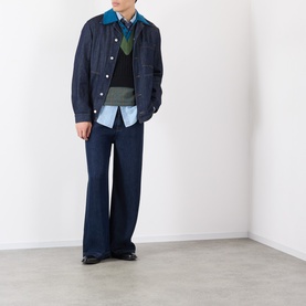 Model wearing Dries Van Noten Indigo Cotton Casual Jacket, styled with wide-leg navy trousers, layered shirt and knit vest.