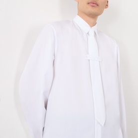 Model wearing Dries Van Noten white cotton casual shirt with attached tie detail, long sleeves and point collar.