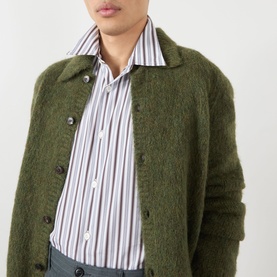 Model wearing Dries Van Noten Croom Striped Shirt in white with vertical stripes, styled under a green fluffy knit cardigan.