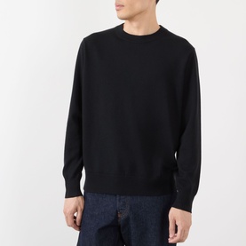 Model wearing Dries Van Noten Muchi Knit Sweater in black; crew neck, long sleeves, ribbed trims, styled with dark denim jeans.