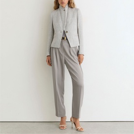 Model wearing Reiss grey tailored blazer and matching trousers, styled with a light top and nude heeled sandals.