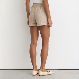 Model wearing Reiss beige shorts with elasticated waist and contrast stitching, styled with cream perforated ballet flats