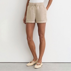 Model wearing Reiss beige drawstring shorts with cuffed hem, styled with cream ballet flats