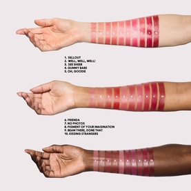 MAC $ellout lipstick shade range swatched across three arms in light, medium, and deep skin tones, showing 9 shades from nude pink to deep red.