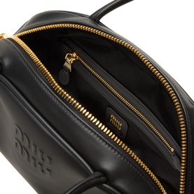 Miu Miu Beau Softy Logo Bag in black leather, open interior view showing gold-toned zip-around fastening and embossed logo detail.