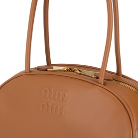 Miu Miu Beau Softy Logo Bag in cognac leather, close-up showing embossed logo, gold-toned zip hardware and top handles with keeper loop.