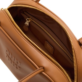 Miu Miu Beau Softy Logo Bag in cognac leather, open top view showing tan interior, zip-around fastening with gold-toned hardware and embossed logo