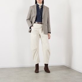 Model wearing Nili Lotan stone wide-leg cotton trousers, styled with a grey blazer, navy shirt and brown ankle boots.