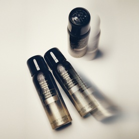 Oribe Gold Lust Dry Heat Protection Spray in black and gold packaging, shown as a group of four bottles on a white surface