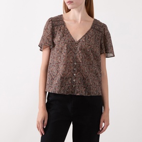 Model wearing Paige dark brown multi floral silk blouse with V-neck, flutter sleeves and button front, styled with black trousers.