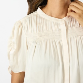 Model wearing Paige Antique White top with pintuck detailing, lace trim panel, and short puffed sleeves, close-up detail view