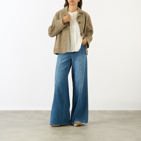 Model wearing Paige Antique White top with taupe cropped jacket and wide-leg blue denim jeans.