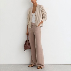 Model wearing Reiss beige wide-leg trousers with striped cardigan, white vest and brown bag with sandals