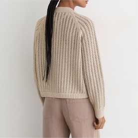Model wearing Reiss beige open-knit crochet jumper, back view, styled with taupe trousers