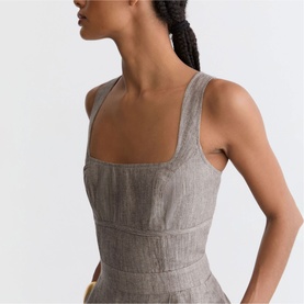 Model wearing Reiss beige sleeveless dress with square neckline and fitted bodice, side profile view showing back detail.