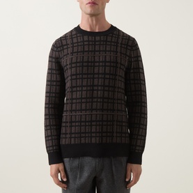 Model wearing Tiger of Sweden Dusty Brown Melange merino wool crew neck jumper with checked jacquard pattern, styled with grey trousers.