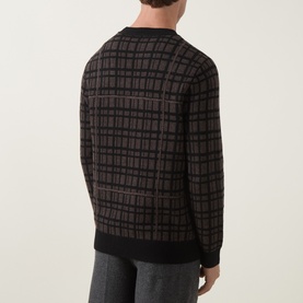 Model wearing Tiger of Sweden crew neck in Dusty Brown Melange, check jacquard knit, back view, styled with grey trousers