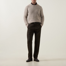 Model wearing Tiger of Sweden stone crew neck knit in yak, alpaca and wool blend, styled with dark tailored trousers and black shoes.