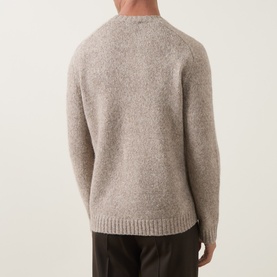 Model wearing Tiger of Sweden Stone crew neck knit, rear view, styled with dark brown trousers