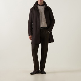 Model wearing Tiger Sweden Stone Crew Neck knit, styled with dark overcoat, olive trousers and black leather shoes.