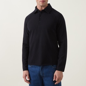 Model wearing Tiger of Sweden Night Sky wool polo with long sleeves and button placket collar, styled with blue jeans.