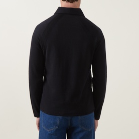 Model wearing Tiger of Sweden Night Sky wool polo knitwear, rear view, styled with blue jeans