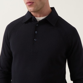 Model wearing Tiger of Sweden Night Sky wool polo with three-button placket, long sleeves, and chest pocket, styled with white crew neck underneath