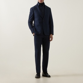 Model wearing Tiger of Sweden Easer Single-Breasted Suit Jacket in Sea navy, styled with matching trousers, dark rollneck and black loafers