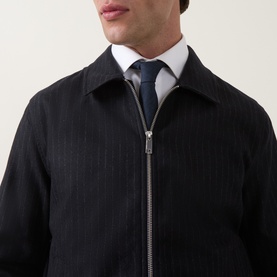Model wearing Tiger of Sweden Blue Function wool suit jacket with full-length zip, styled with white shirt and navy tie
