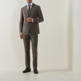Model wearing Tiger of Sweden stone suit jacket and matching trousers, styled with white shirt, tie and dark brown Oxford shoes.