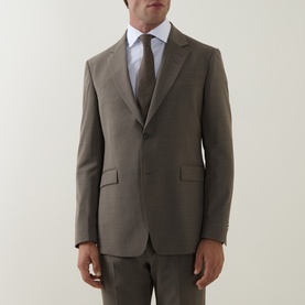 Model wearing Tiger of Sweden stone suit jacket in yak, alpaca and wool blend, styled with matching trousers and brown tie