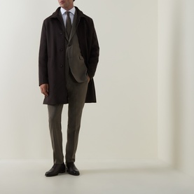 Model wearing Tiger of Sweden Stone suit jacket in yak, alpaca and wool blend, styled with dark overcoat, tie and black dress shoes