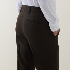 Model wearing Tiger of Sweden Tenser Slim Suit Trousers in Coffee, showing rear welt pockets and belt loops, styled with a white shirt.