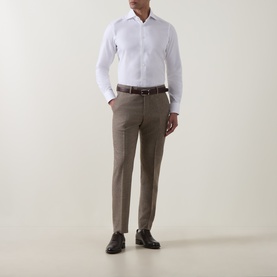 Model wearing Tiger of Sweden Blurywood wool suit trousers with white dress shirt, brown leather belt and dark Oxford shoes.