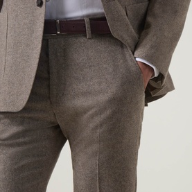 Model wearing Tiger of Sweden Blurywood wool suit trousers with matching jacket and burgundy leather belt