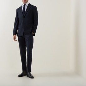 Model wearing Tiger of Sweden Midnight Blue suit trousers with matching blazer, white shirt, tie and black leather shoes