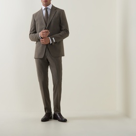 Model wearing Tiger of Sweden stone suit trousers with matching tailored jacket, light blue shirt, tie and black leather dress shoes