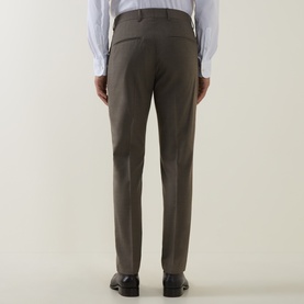 Model wearing Tiger of Sweden stone suit trousers, back view, styled with a white shirt and black leather shoes