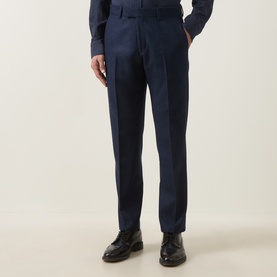 Model wearing Tiger Sweden Suit Trouser in Sea, a navy wool-blend with tailored pleat front, styled with black leather loafers.