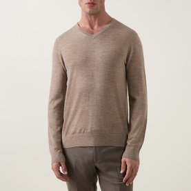 Model wearing Tiger of Sweden Beige Melange wool V-neck jumper, styled with light taupe trousers.