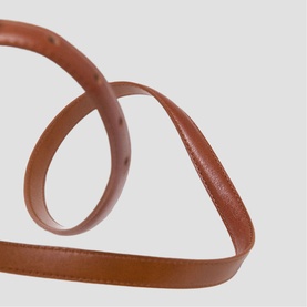 Maje tan leather belt coiled to show slim strap width and punched holes, neutral background
