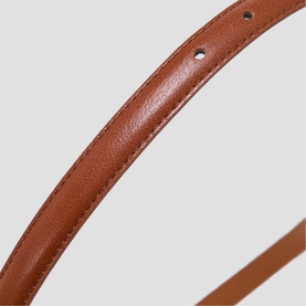Maje tan leather belt with stitch detailing, close-up showing smooth texture and punched hole detail