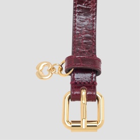 Maje belt in burgundy croc-embossed leather with gold-tone buckle and heart charm detail.