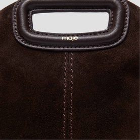 Maje dark brown suede bag close-up showing structured rectangular handle, contrast stitching detail, and gold brand lettering
